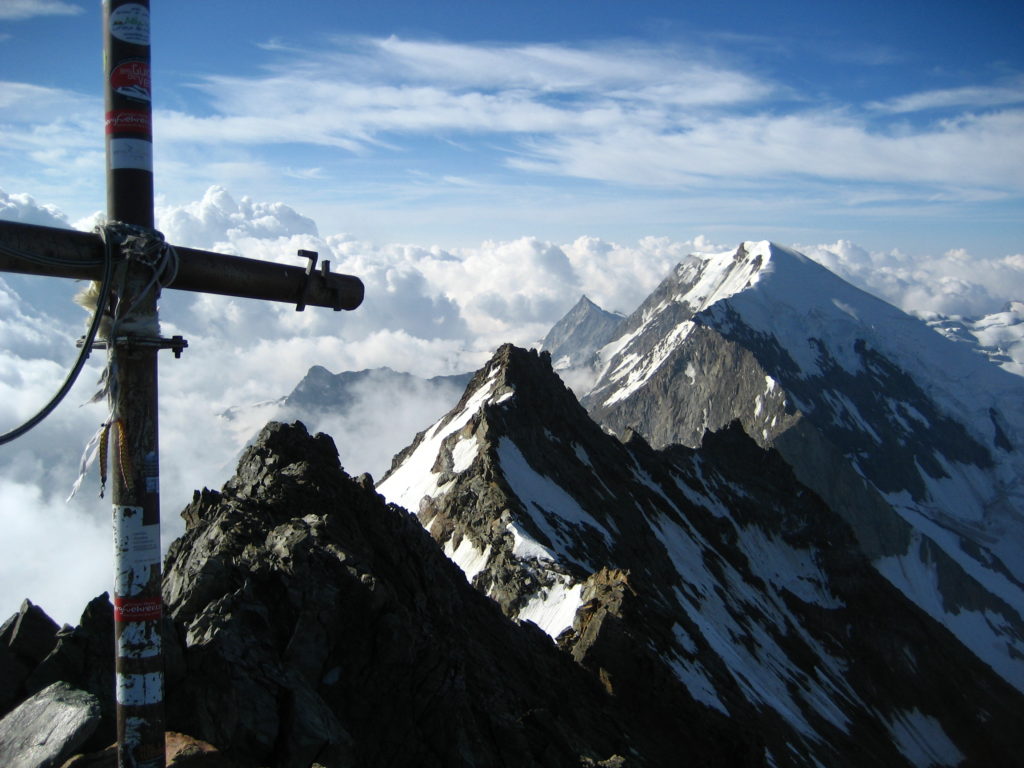 The summit cross with the south ridge and the Weissmies summit